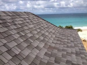 Residential property on the beach with grey asphalt shingles installed. 