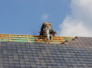 Technician works on installing a new roof on a property.